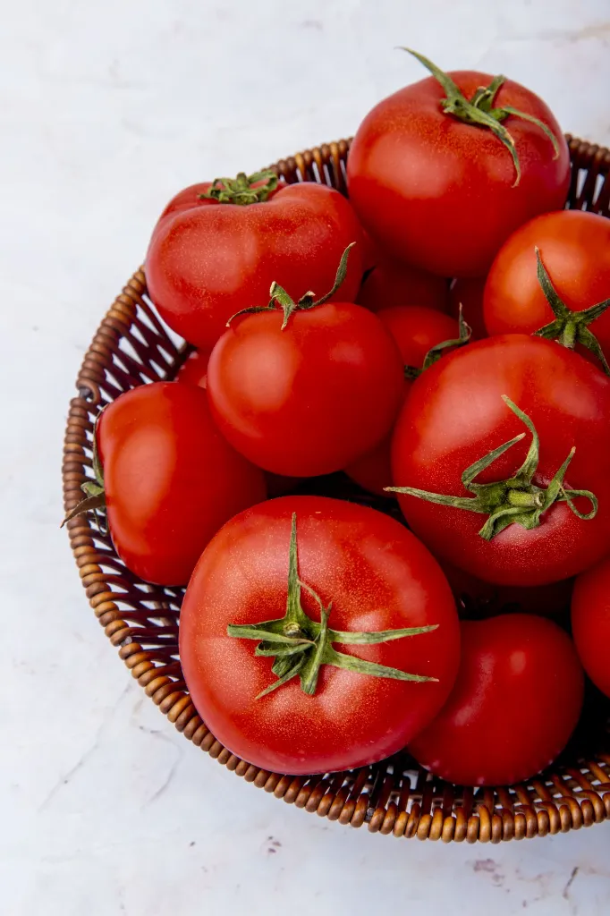 basket-whole-tomatoes-white-surface.webp